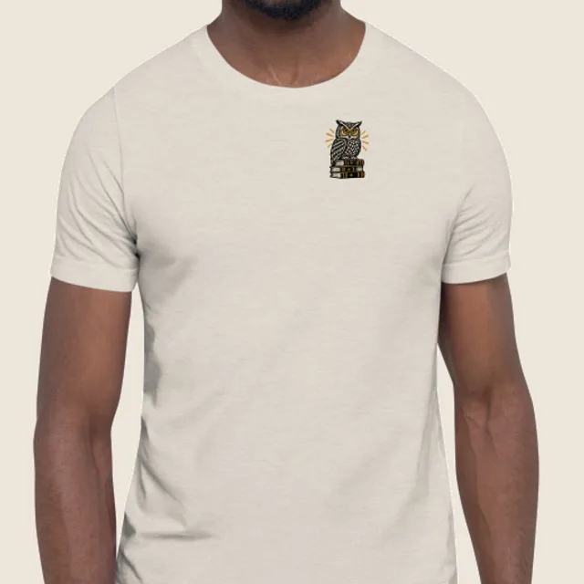 A small linocut owl printed on the left chest of a tee